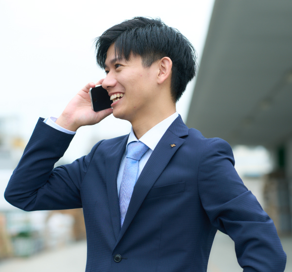 携帯電話でお客様と話をする先輩社員