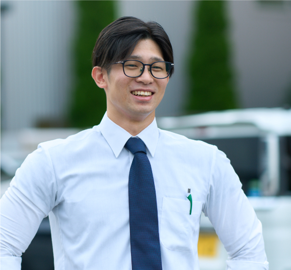 駐車場で微笑む先輩社員