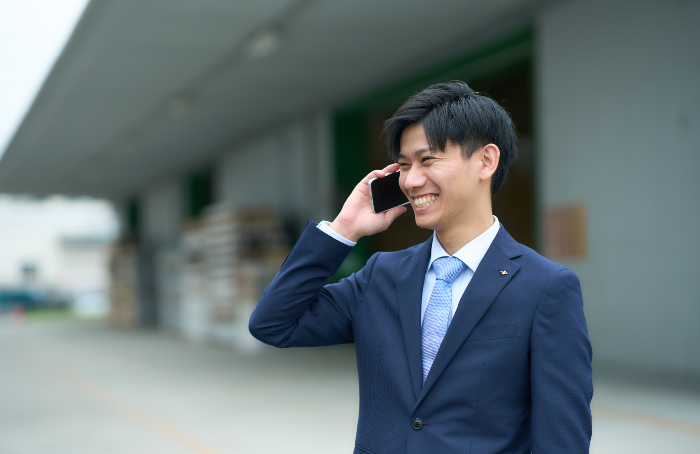 携帯電話でお客様と話をする男性社員